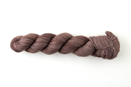 Pink-toned medium brown tonal skein of yarn.