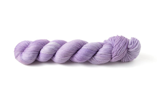 A skein of pastel purple hand-dyed yarn.