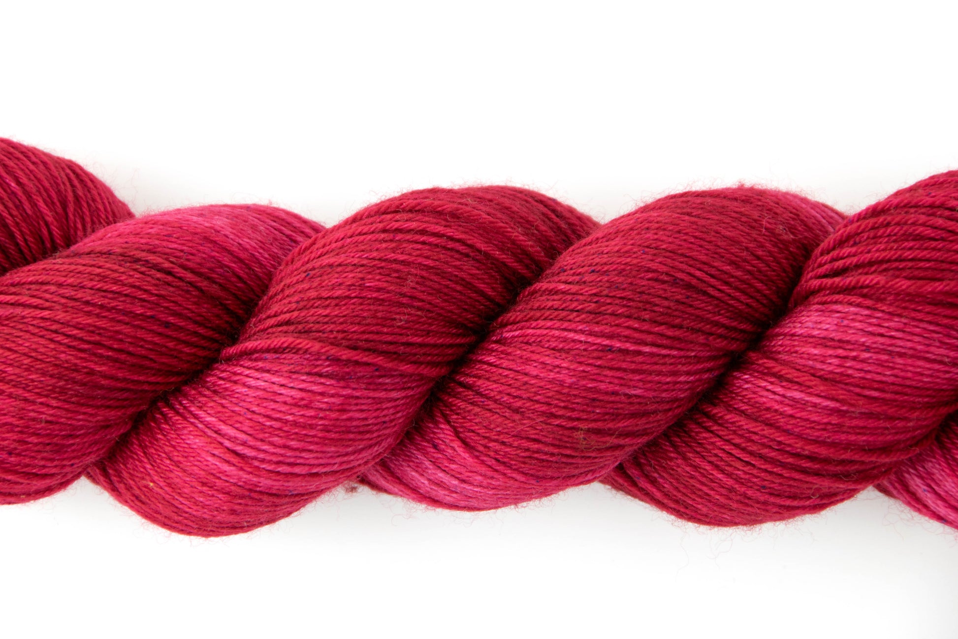 View of the tonal qualities of the yarn, which range from fire red to a dark fuchsia.