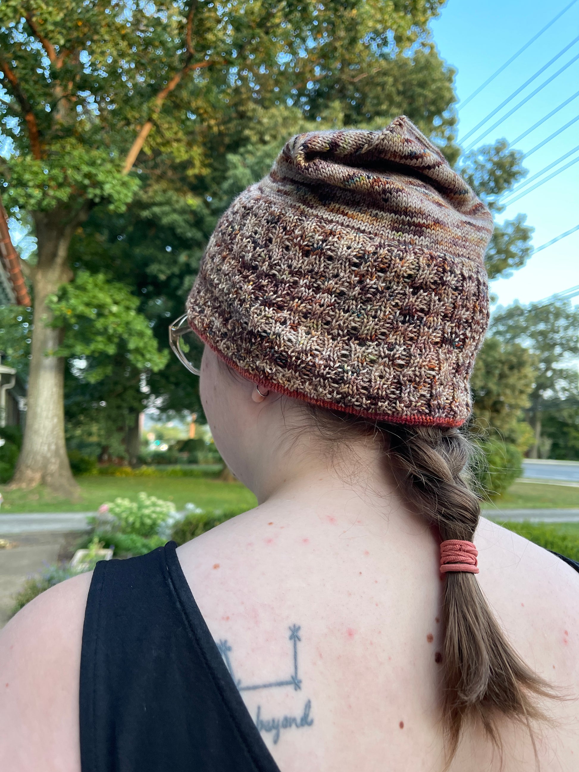 Cat wears a beanie-style knit hat with eyelet texture.