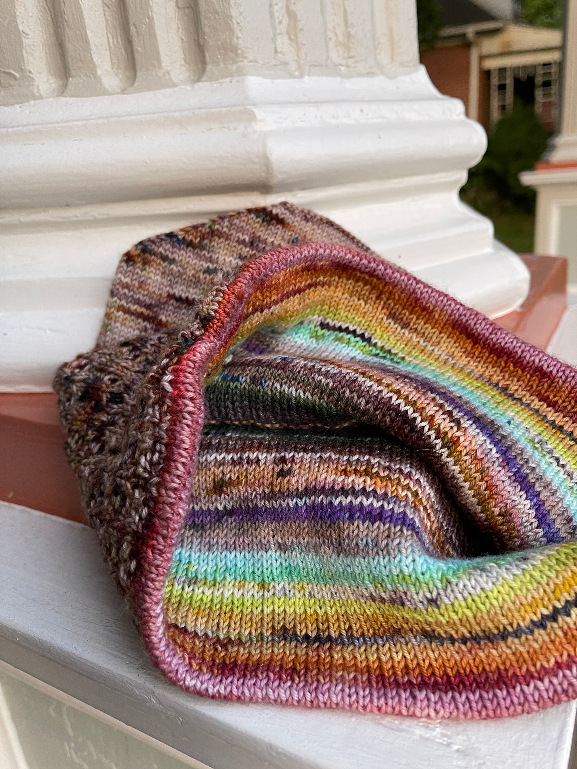 Close view of the inside of the Frightfully Drafty hat, which is striped with rainbow colors.