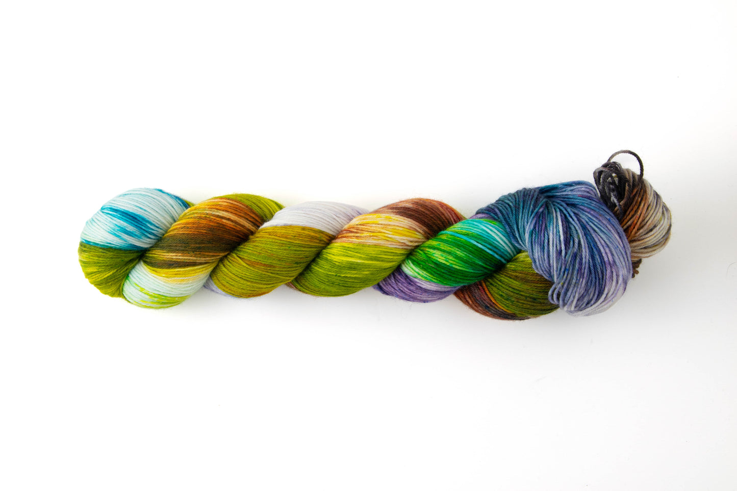 A skein of yarn dyed a muted rainbow with a sepia tone.