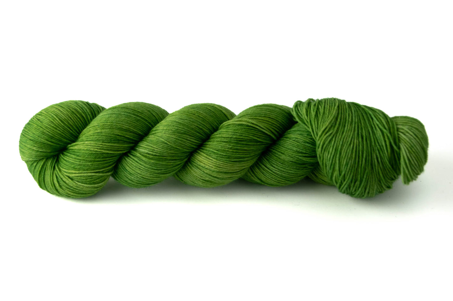A saturated Granny-Smith green skein of tonal wool yarn.