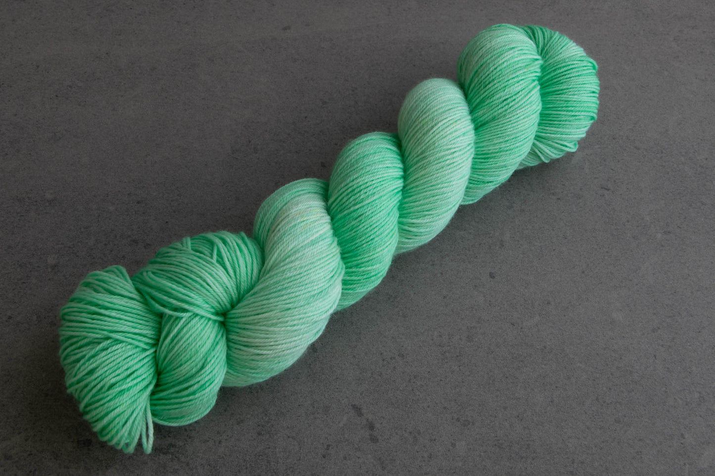 A skein of tonal aqua hand-dyed yarn.