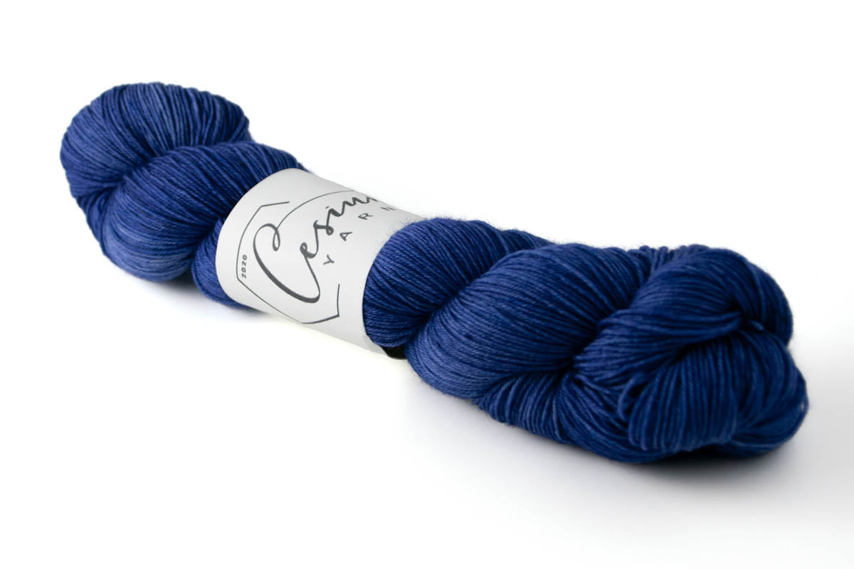 A deep indigo skein of tonal hand-dyed wool yarn.