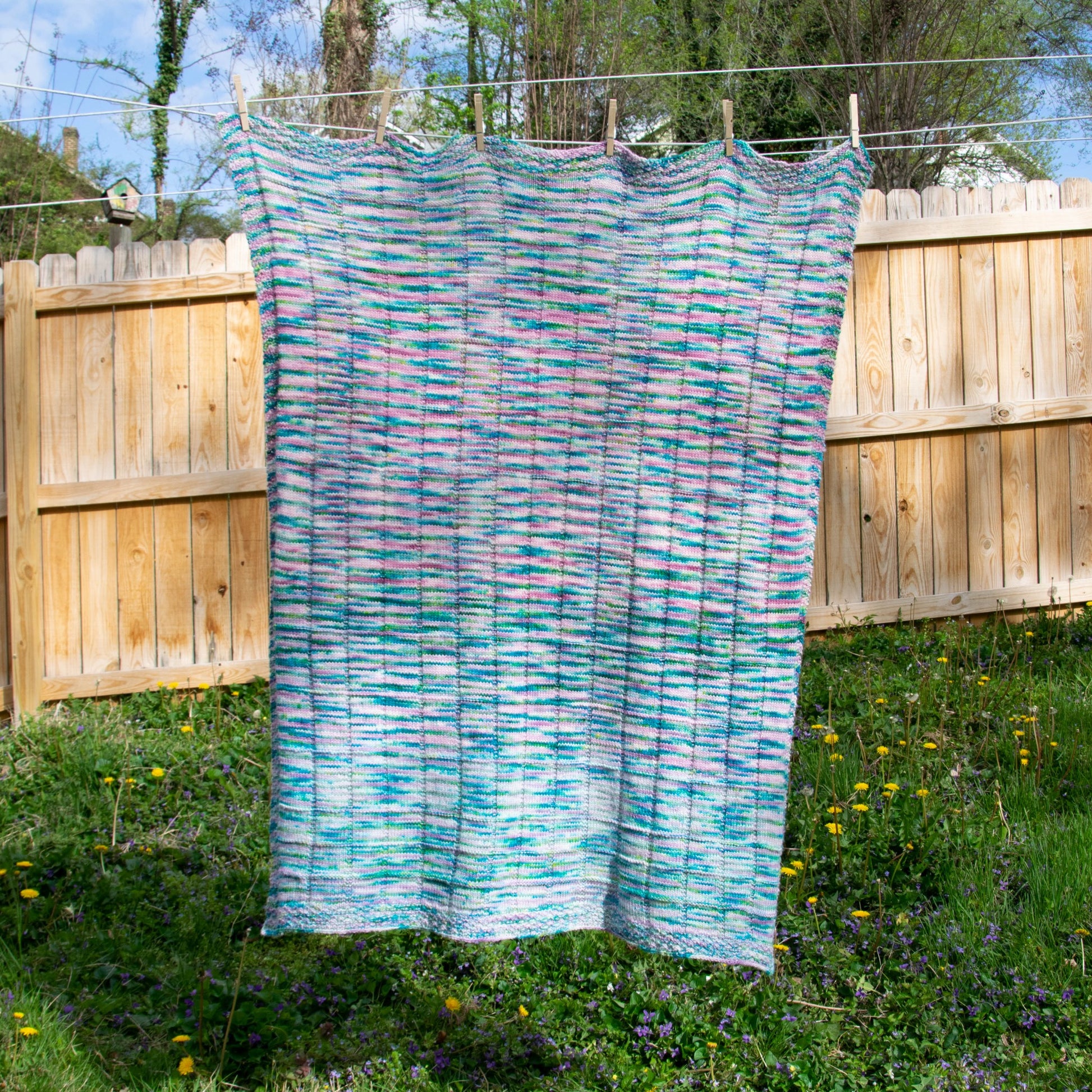 A full view of the Triple Pane blanket hanging on a clothesline, showing that the design is symmetrical across the short axis.