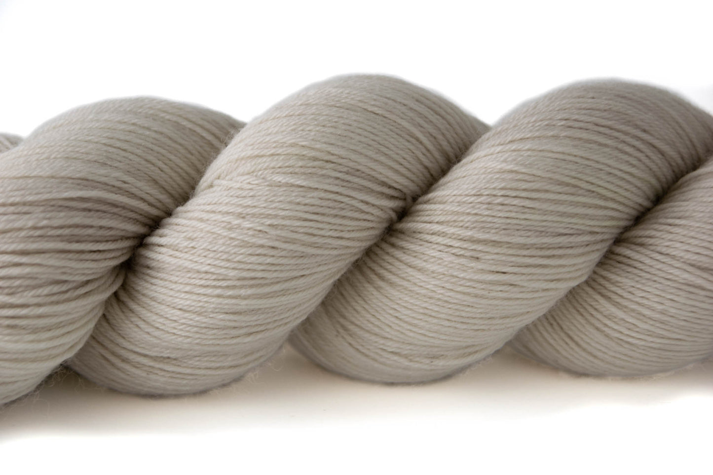 A closeup on neutral bone-white hand-dyed wool yarn.