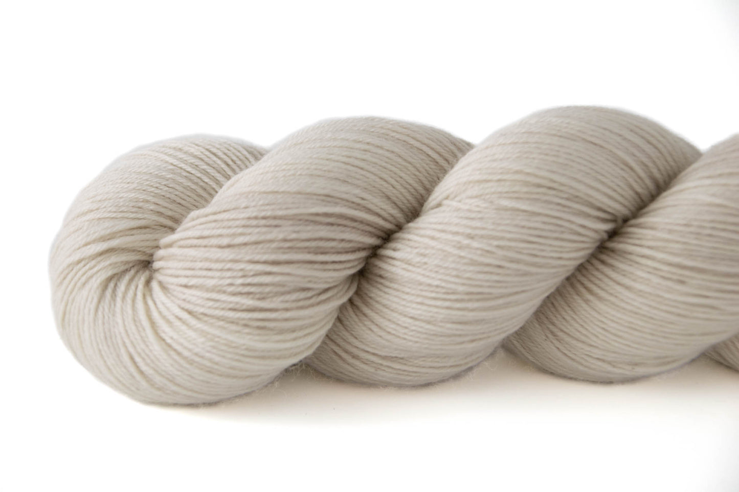 A closeup on neutral bone-white hand-dyed wool yarn.