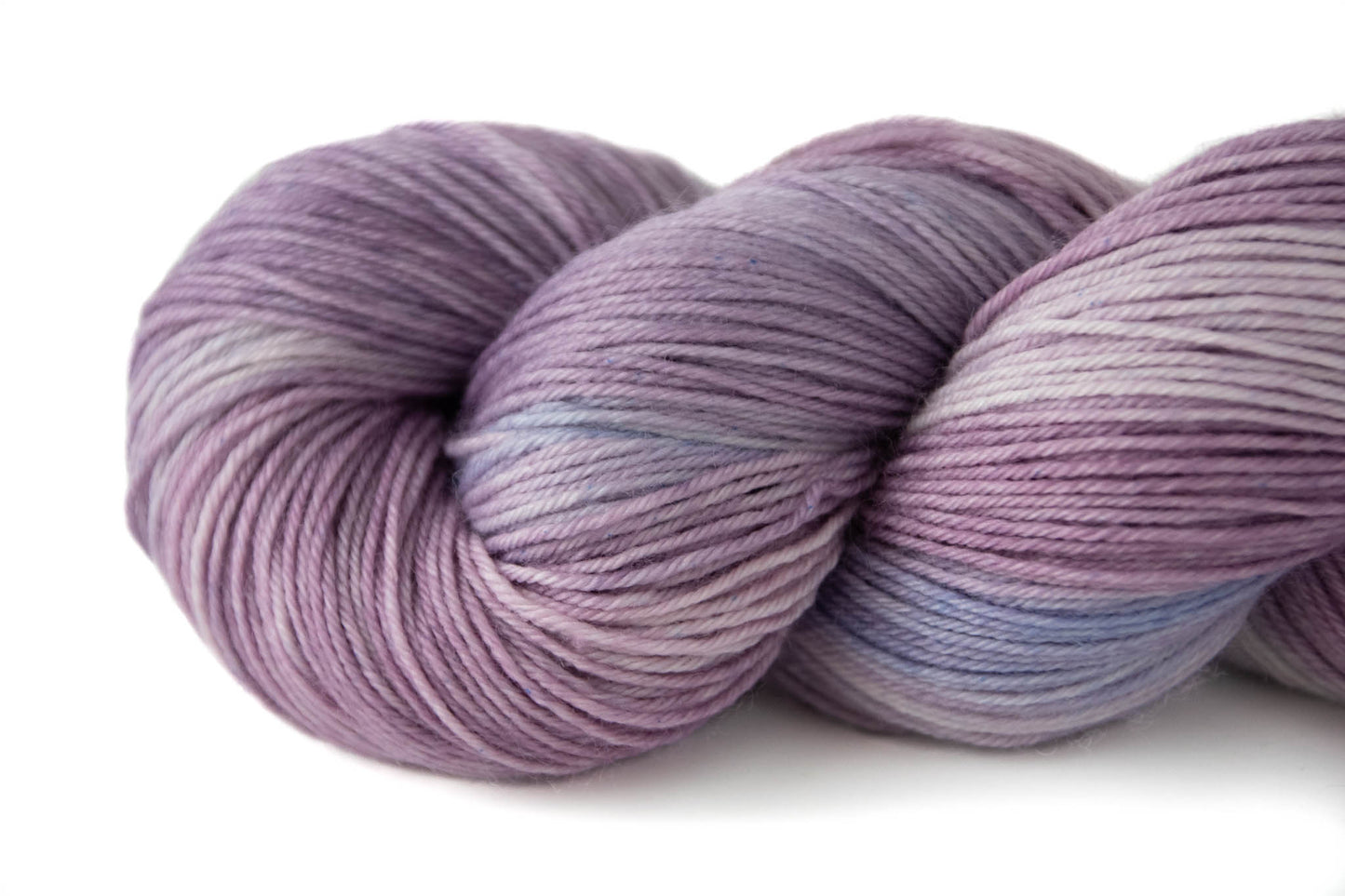 Closeup on the twisted end of a skein of purple tonal yarn.