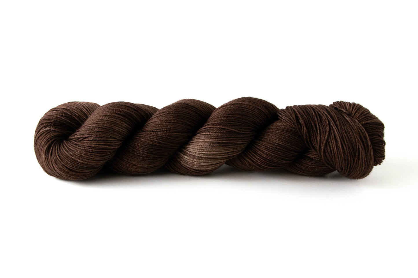 A skein of tonal chocolate brown hand-dyed wool yarn.