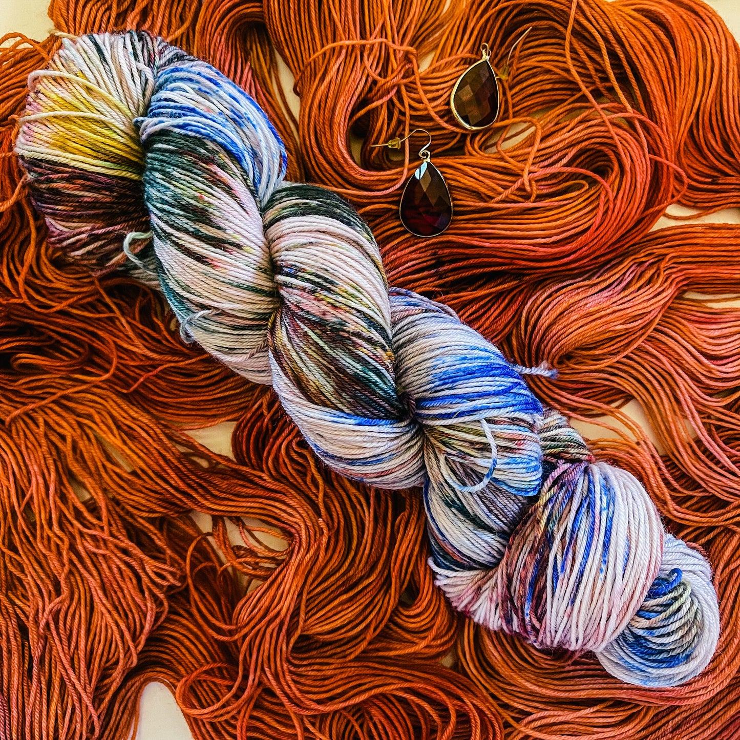 Red Booty Trap colorway with its companion jewel-tone speckled hand-dyed merino yarn