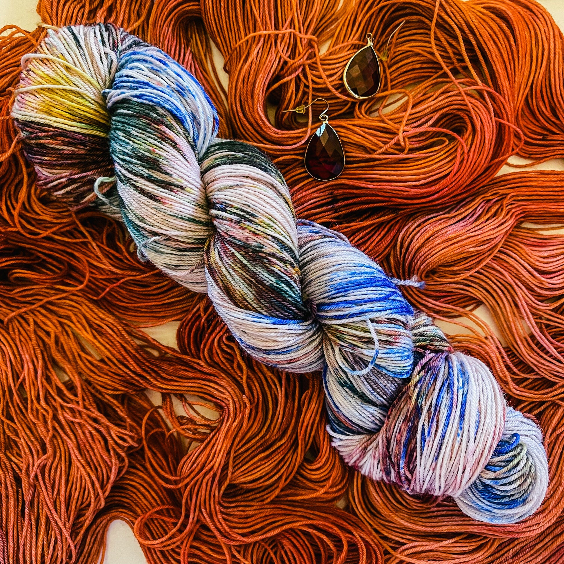 Red Booty Trap colorway with its companion jewel-tone speckled hand-dyed merino yarn