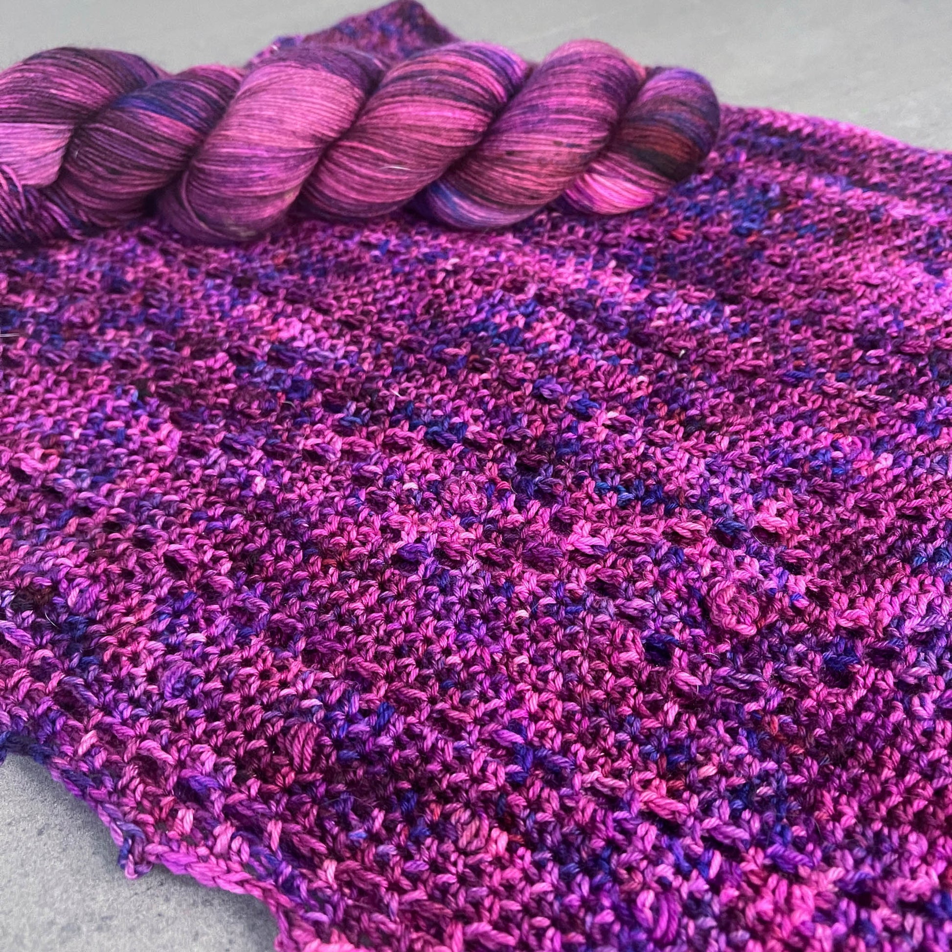 A crochet cowl highlighting the diamond-patterned section