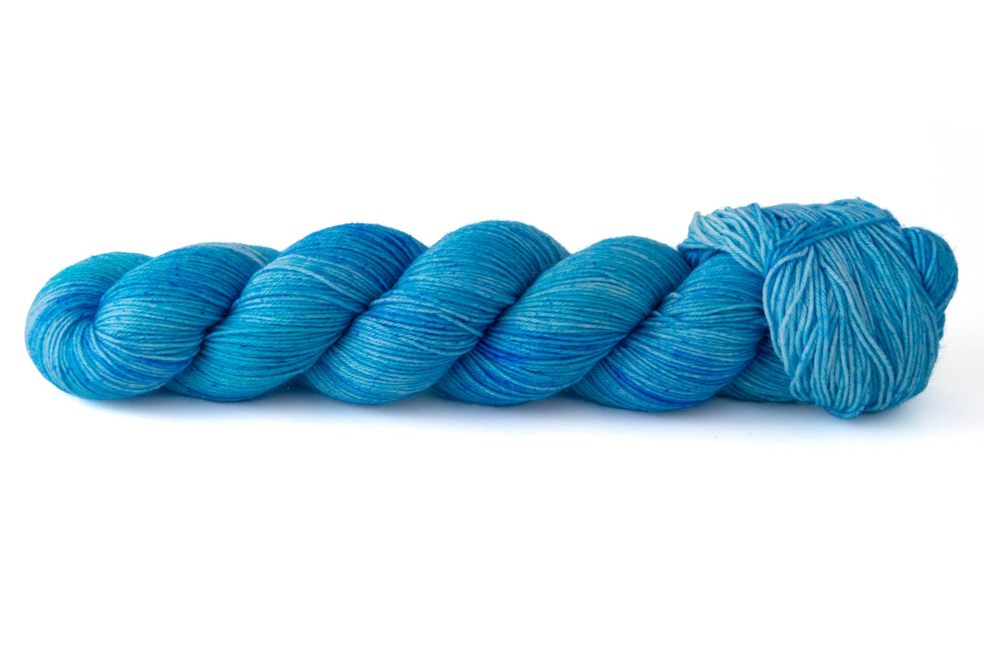 A skein of highly tonal hand-dyed blue yarn ranging from indigo to aqua.