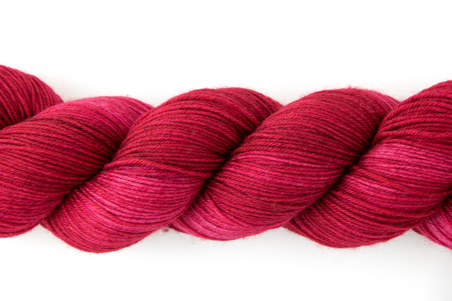 View of the tonal qualities of the yarn, which range from fire red to a dark fuchsia.