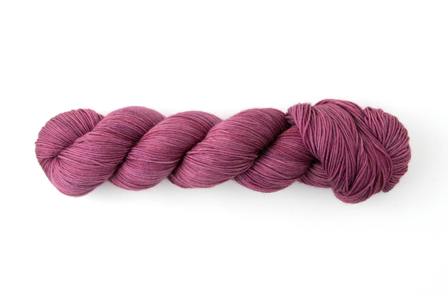 A skein of mauve to purple yarn with the occasional navy speckle.