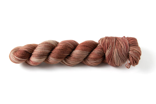 A skein of variegated yarn in rusty red and light tan.