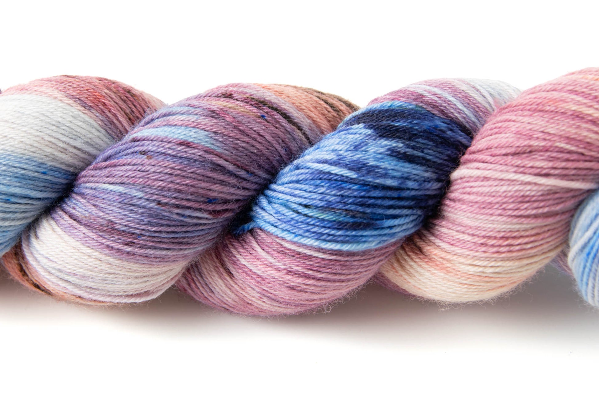 Close vies of the variegated nature of the yarn ad the small speckles of color on top of the larger swathes of color.