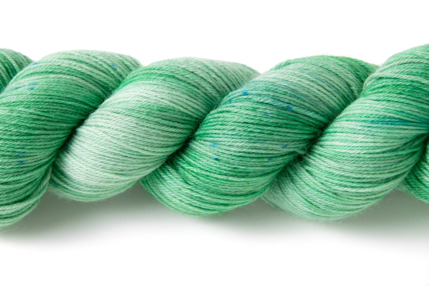 Close up on the tiny blue speckles in the colorway, and the variation in depth of shade of the green.