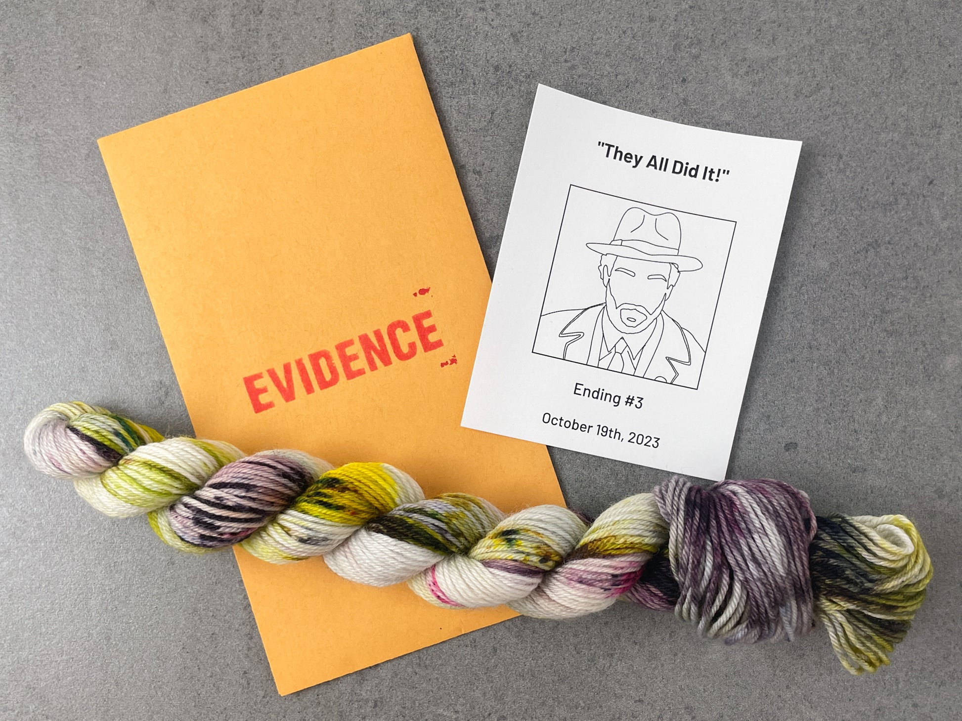 A white, purple, yellow, and green skein of yarn on top of an envelope stamped with "Evidence" and a card with a drawing of the FBI official on it.