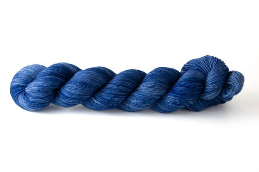 A skein of highly tonal hand-dyed deep blue yarn.