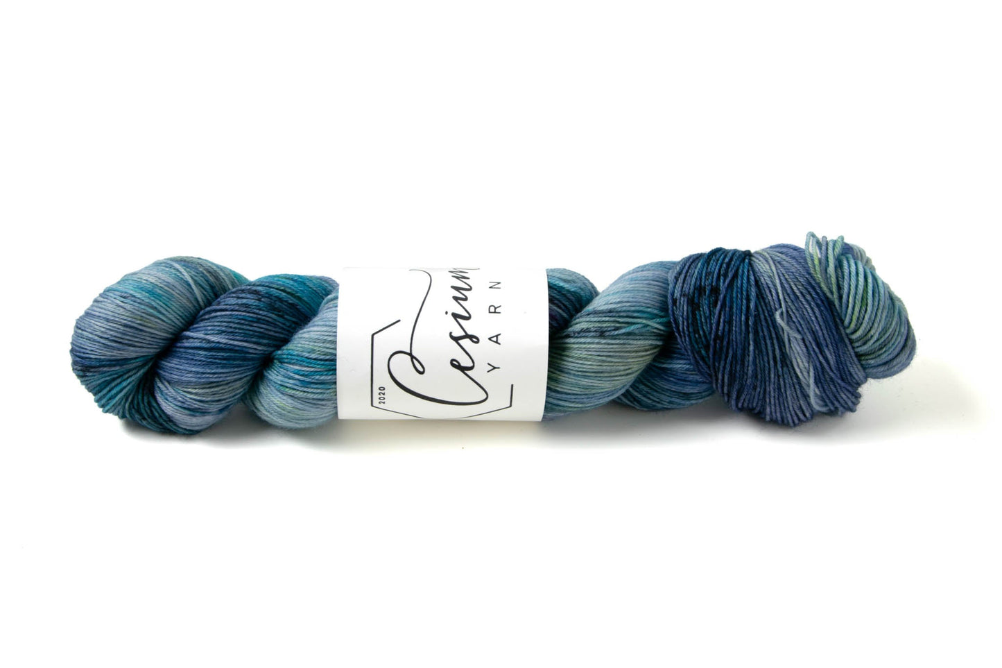A skein of variegated blue yarn with green sections.
