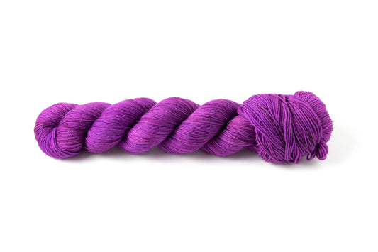 A skein of electric purple yarn with tiny micro-speckles.