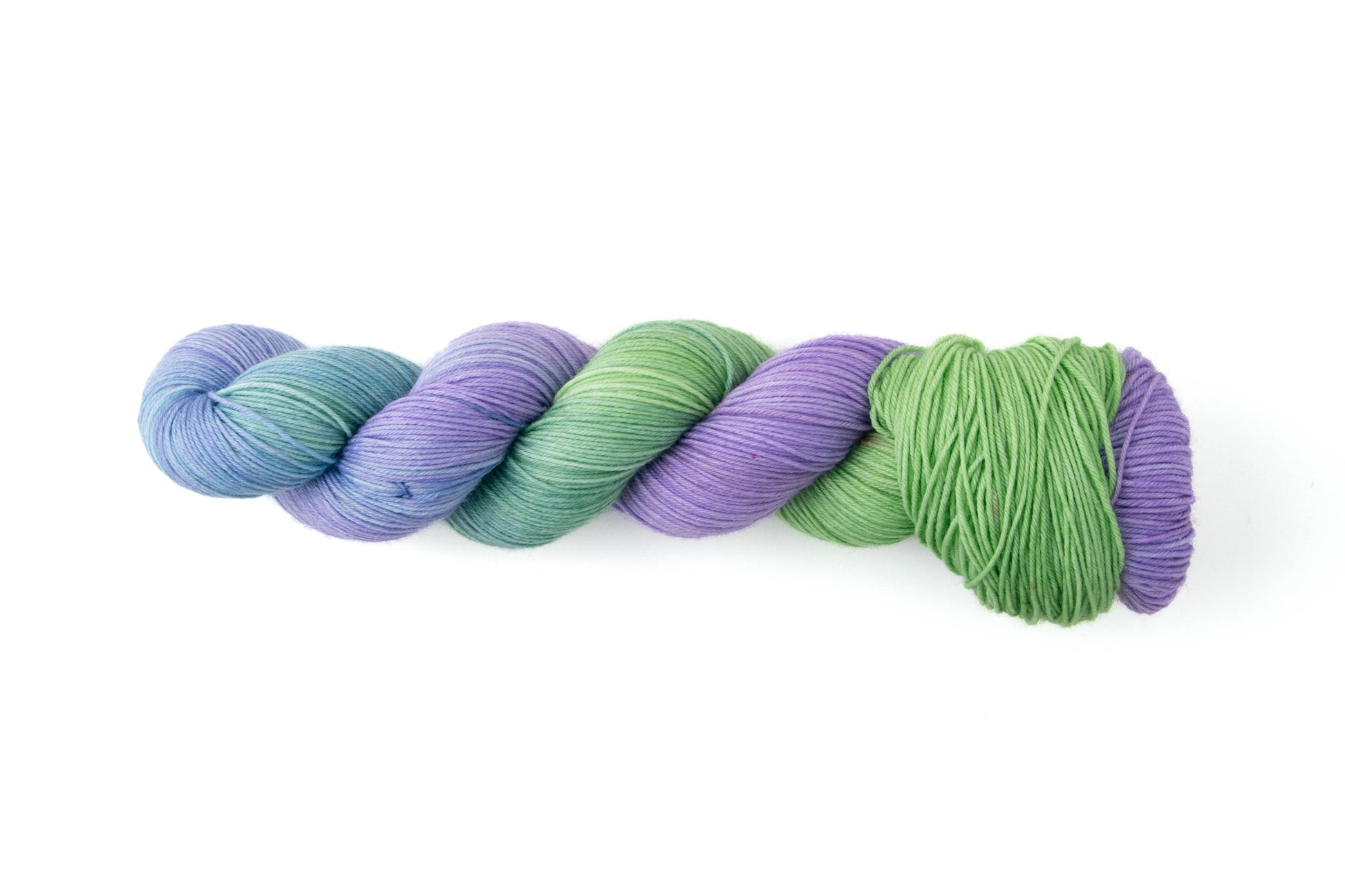 A skein of yarn that fades from spring green to bright purple, with a stop at sky blue in the middle.