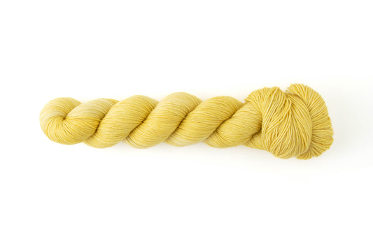 A skein of yellow tonal hand-dyed yarn.
