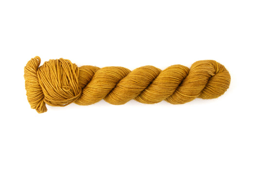 A skein of dark mustard yellow hand-dyed wool yarn.