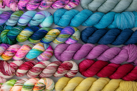 All twelve colorways in the Mamma Mia collection laid out in a grid. Note: You will not receive the skeins pictured, you will receive mini skeins.