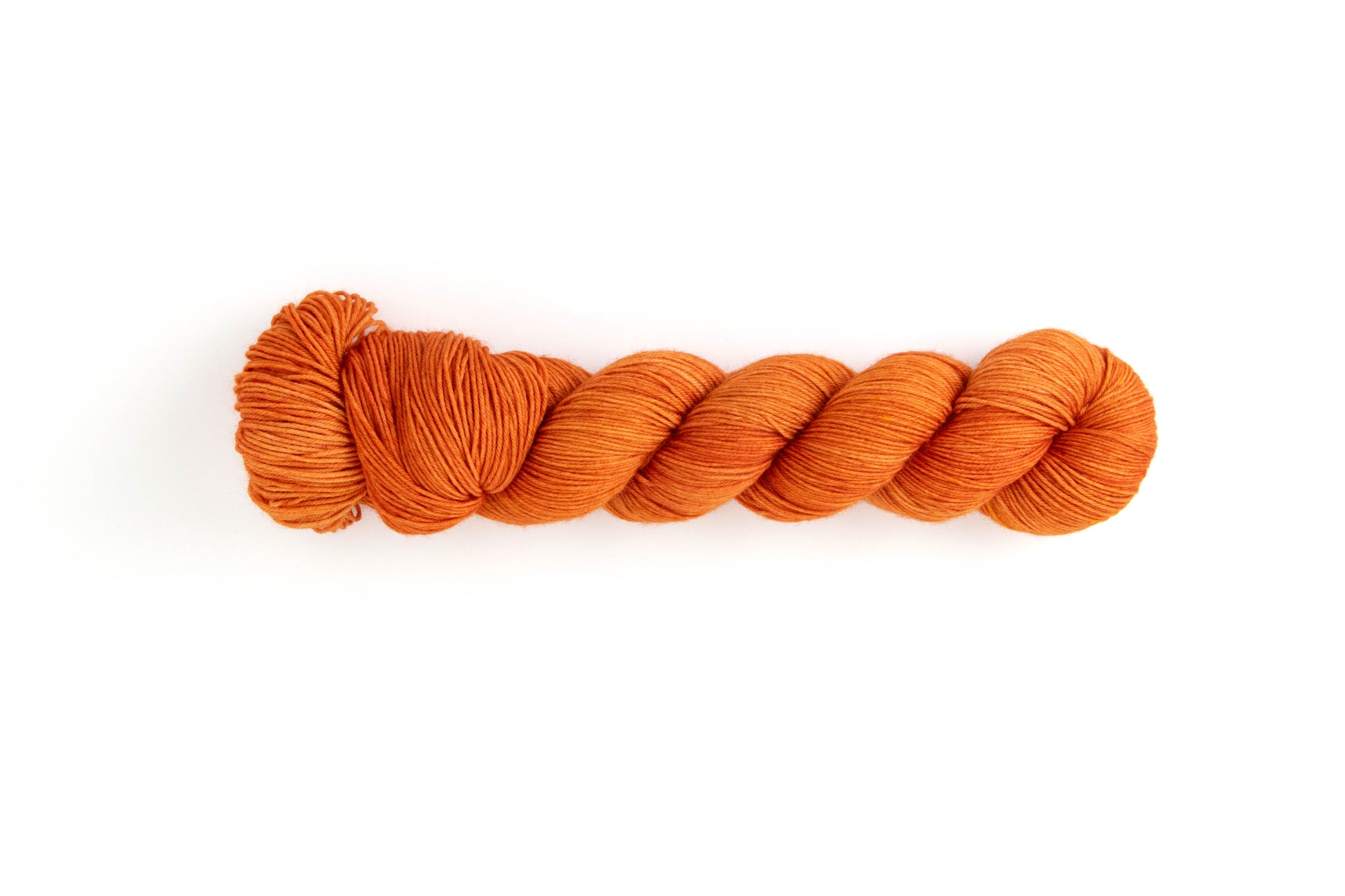 A highly saturated, almost-burnt orange color tonal hand-dyed yarn.