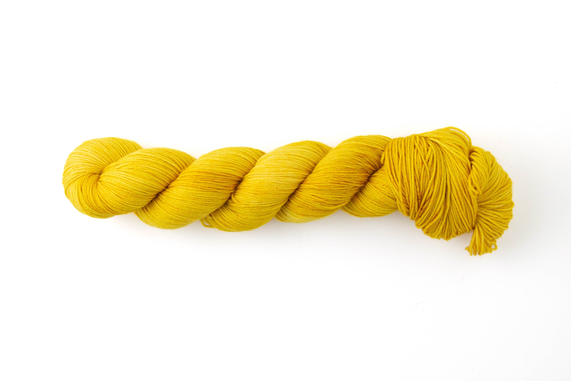 A bright yellow skein of yarn with tiny orange speckles.