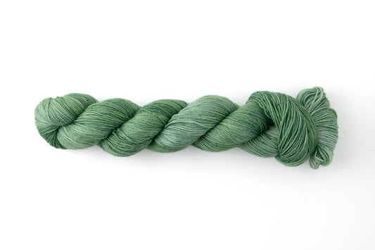 A highly tonal green yarn with blue microspeckles.