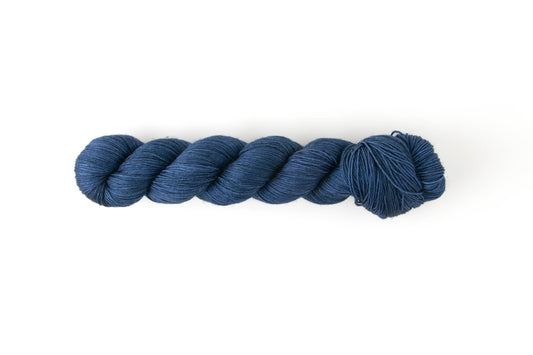 A denim-colored skein of hand-dyed yarn.