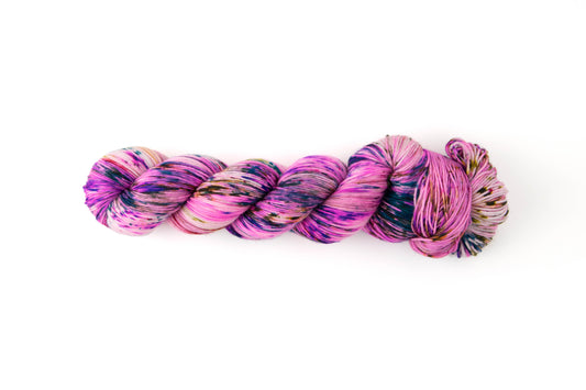 A skein of pink yarn with purple, orange, and green speckles.