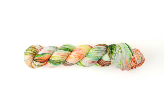 A skein of bright orange, yellow, and green with sections of subdued red, green, and lightest gray,