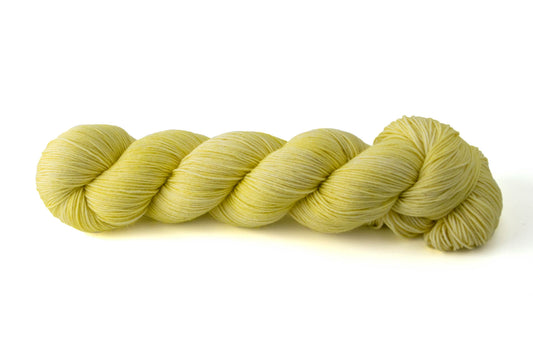 A bright yellow skein of tonal hand-dyed wool yarn.