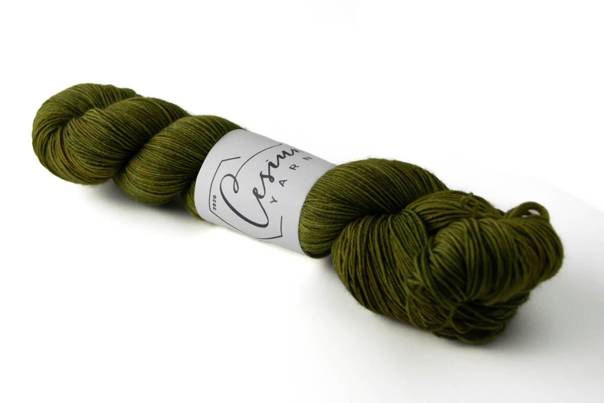 A skein of tonal green hand-dyed wool yarn.