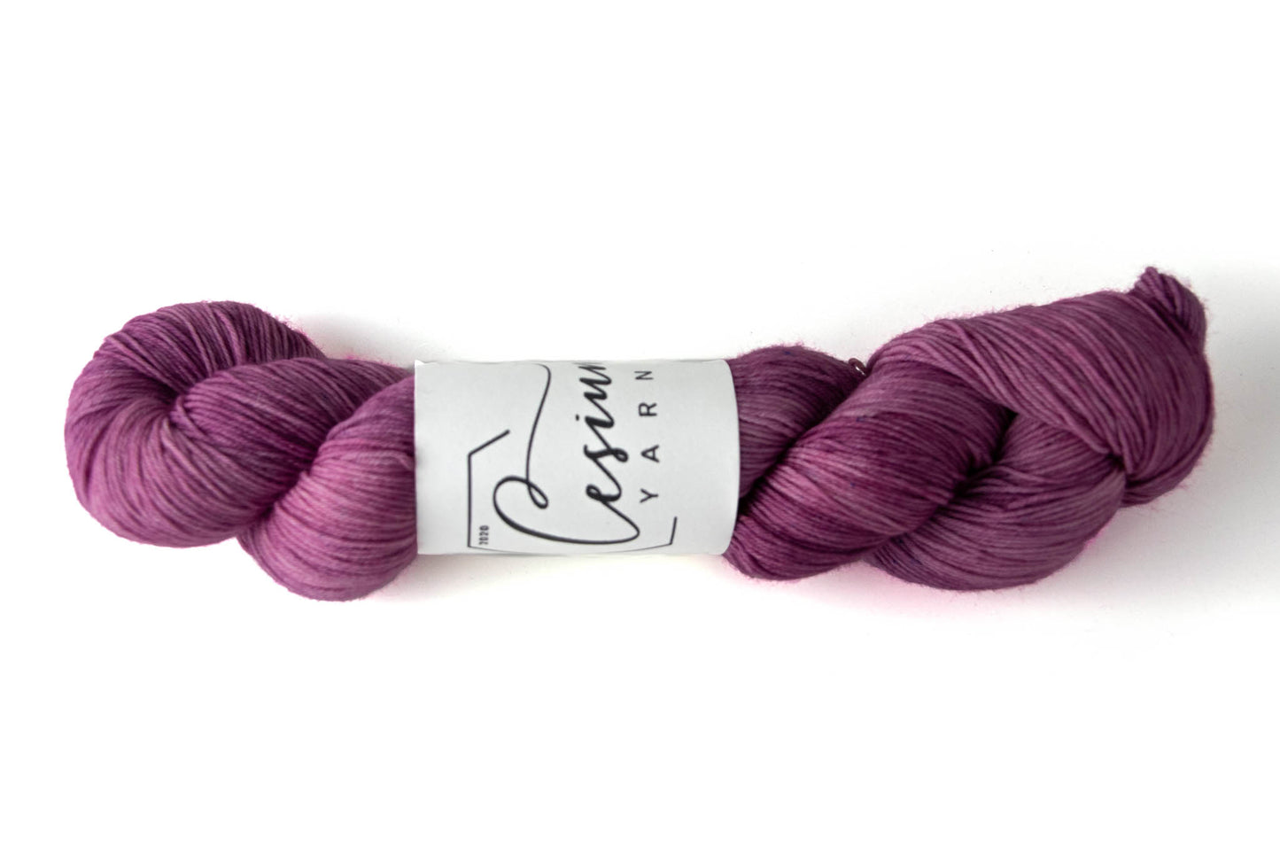 A skein of hand-dyed purple tonal yarn.