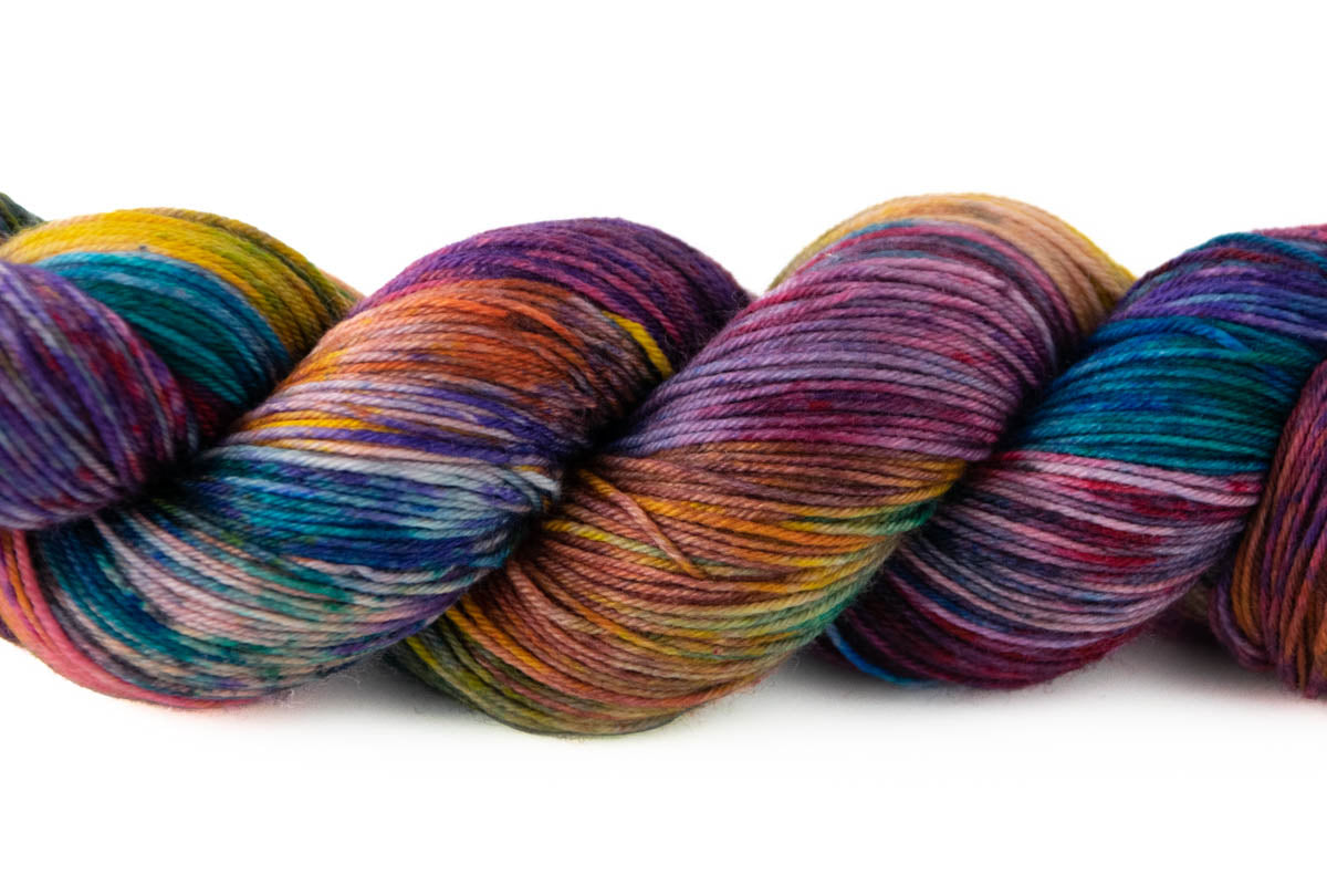 A closeup on the variegated texture of the yarn and the patches of rainbow colors on it.