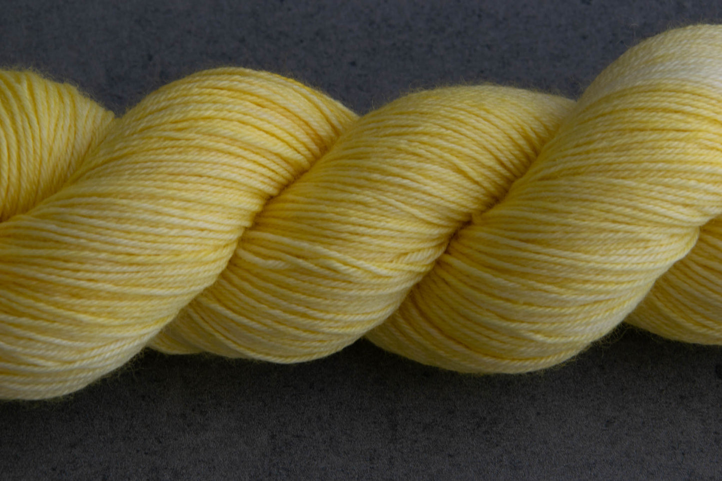 View of the tonal qualities of a skein of yellow hand-dyed yarn.