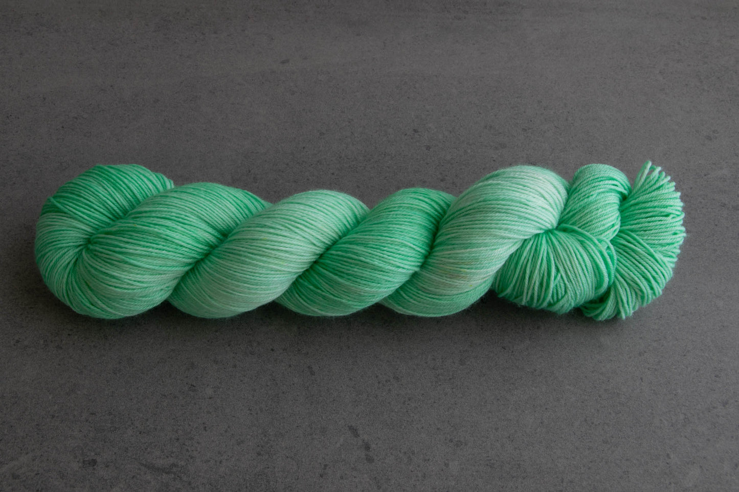 A skein of tonal aqua hand-dyed yarn.