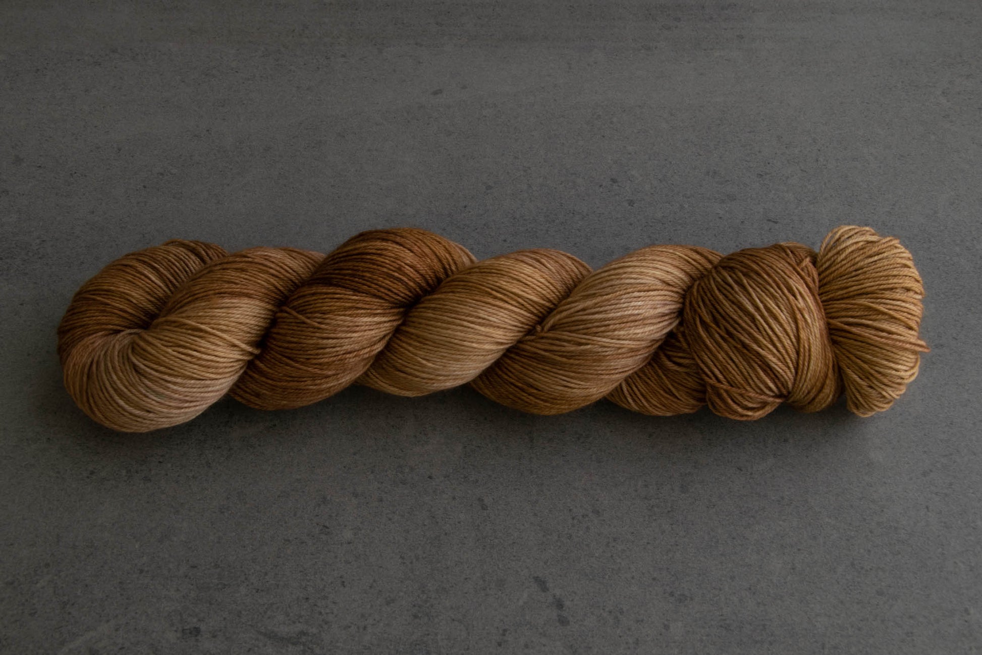 A skein of warm brown tonal hand-dyed yarn.