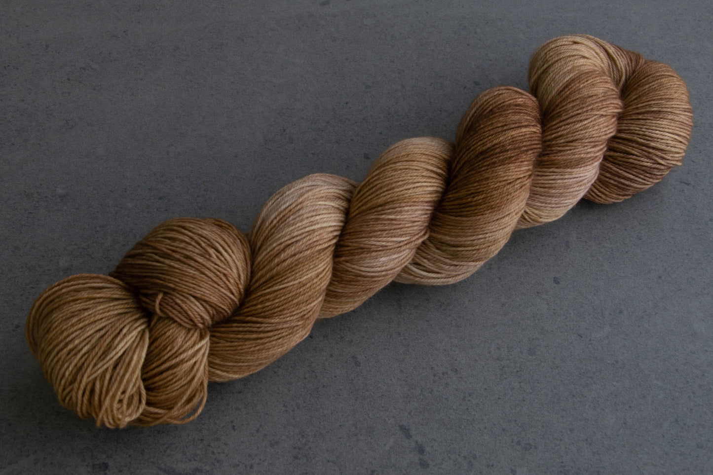 A skein of warm brown tonal hand-dyed yarn.