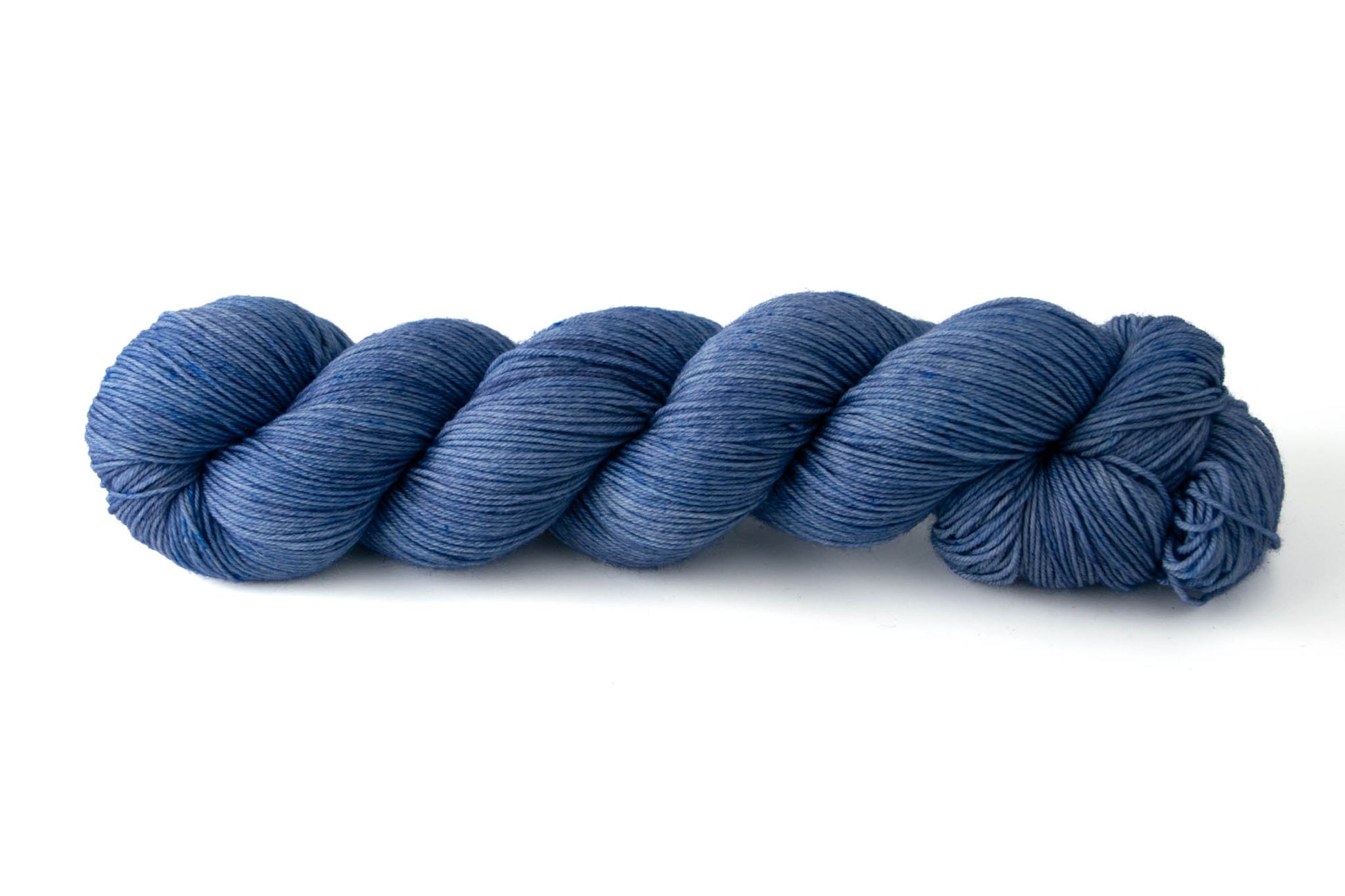 A light denim-blue skein of tonal hand-dyed wool yarn.