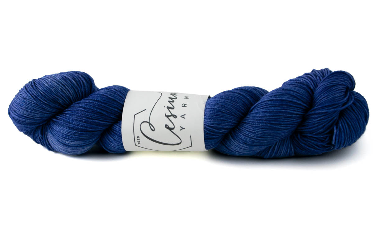A deep indigo skein of tonal hand-dyed wool yarn.