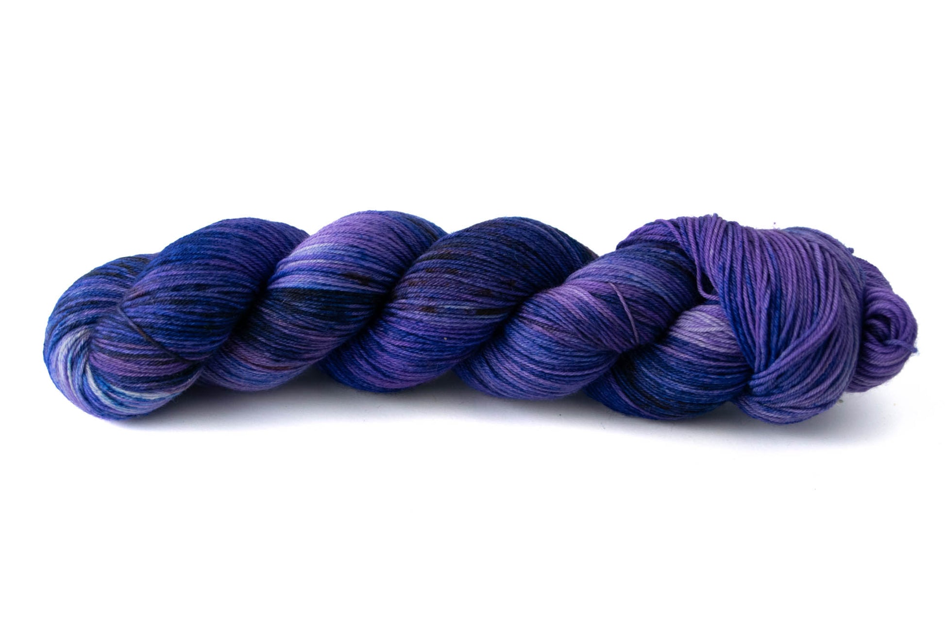 A skein of variegated violet and deep sky blue hand-dyed wool yarn.