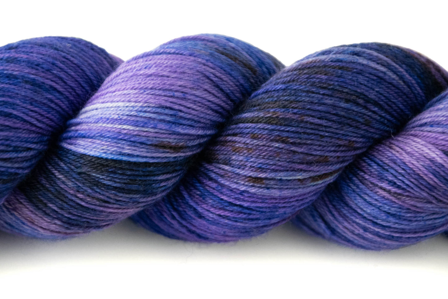 Close view of the many shades of purple and blue, as well as small speckles of brown and tiny patches of white.