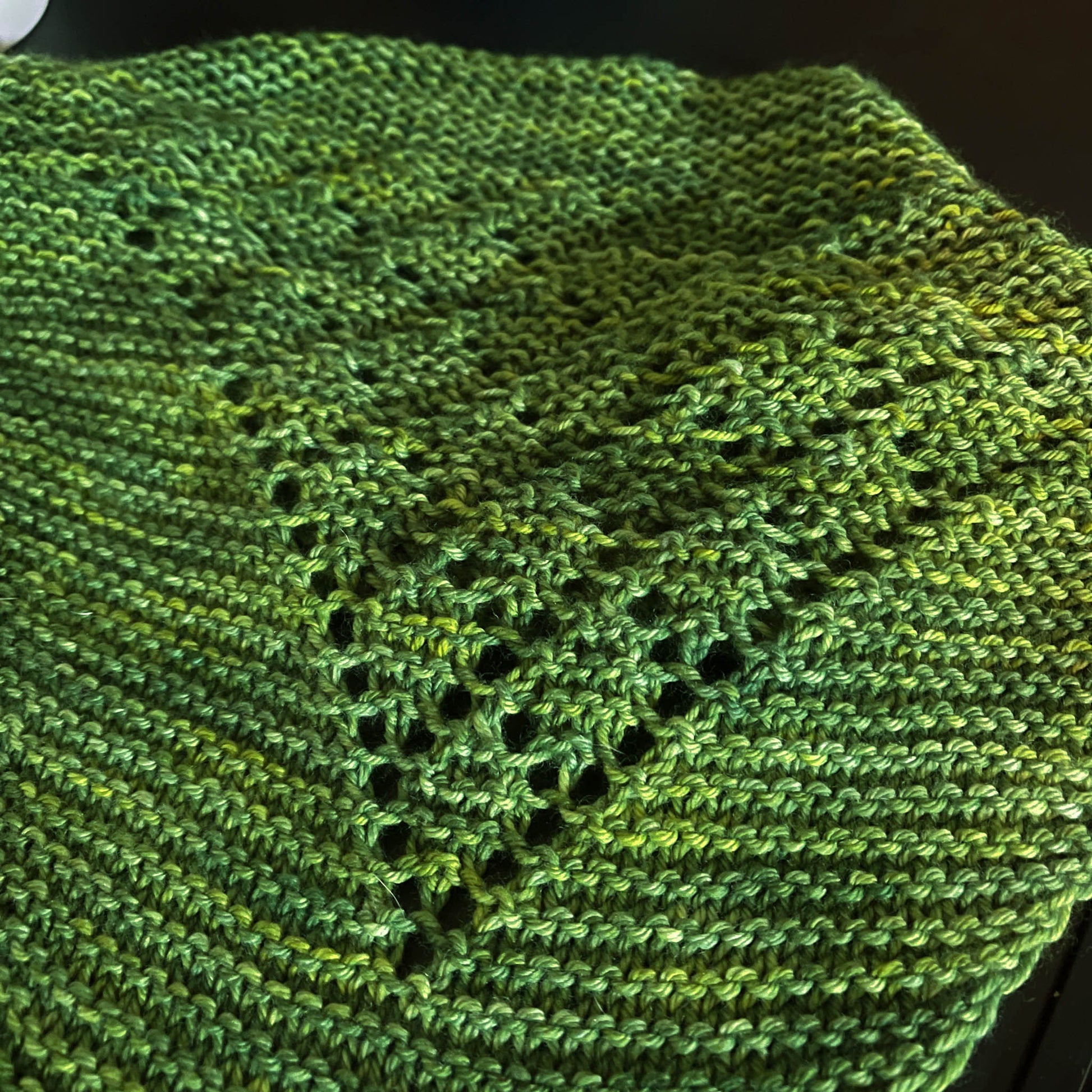 A green knit bandana cowl with lace details.
